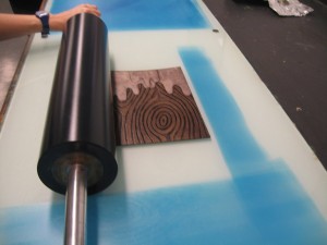 Rolling the plate with a transparent blue ink.