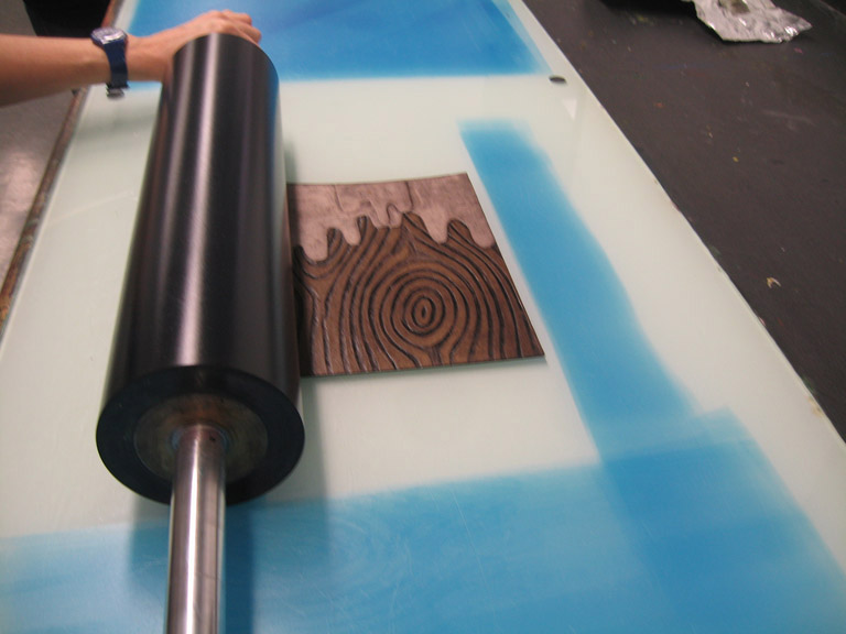 Rolling the plate with a transparent blue ink.