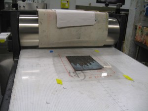 The plate, centered in the template on the press bed.