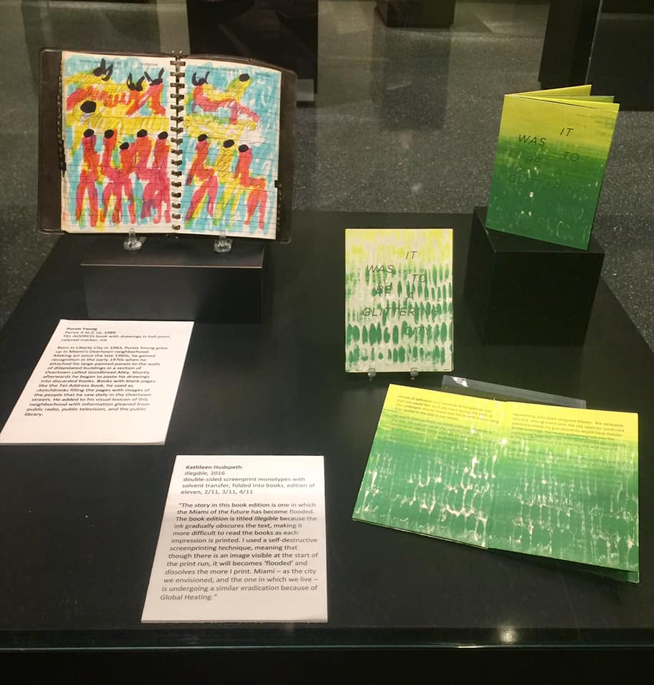 Image depicts colorful, hand-made books by two artists in a vitrine.