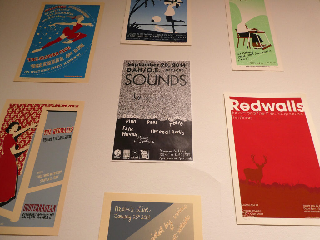 A close up view of screenprinted posters with a digitally printed event poster in the center.